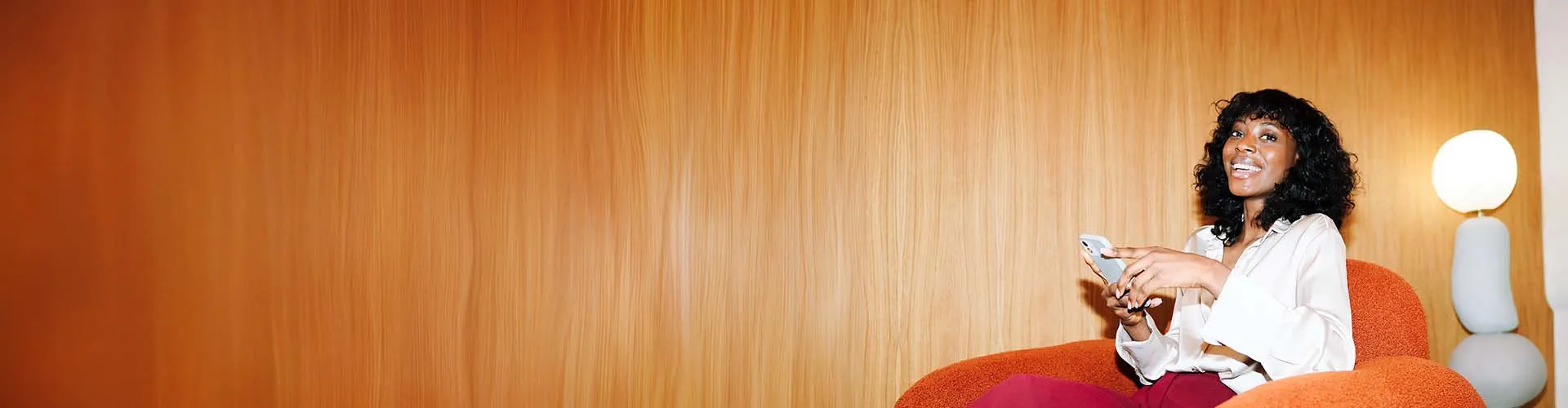 Une femme souriante utilisant la solution QAPA sur son smartphone Une femme souriante utilisant la solution QAPA sur son smartphone