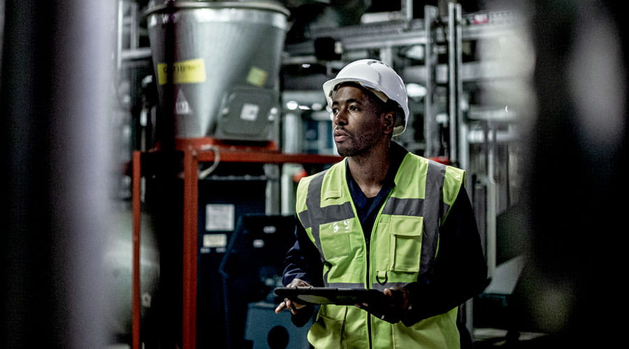 Worker operating machinery in industrial plant Worker operating machinery in industrial plant