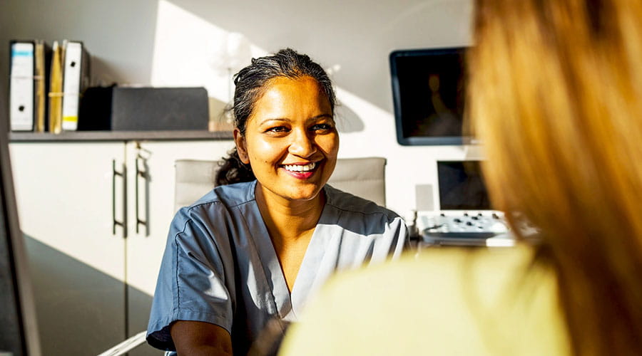 Nurse talking with patient at desk Nurse talking with patient at desk
