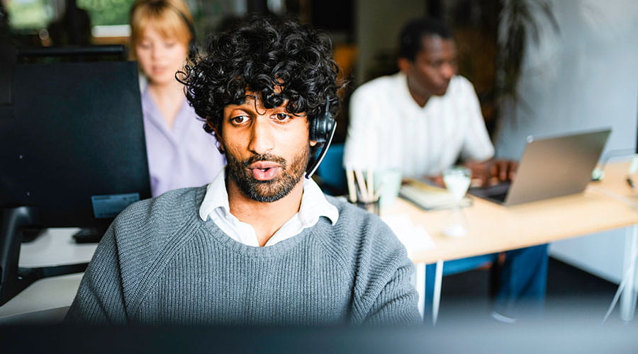 Man working on laptop in office environment Man working on laptop in office environment