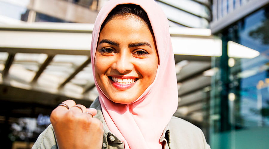 Woman smiling and taking selfie in workplace setting Woman smiling and taking selfie in workplace setting