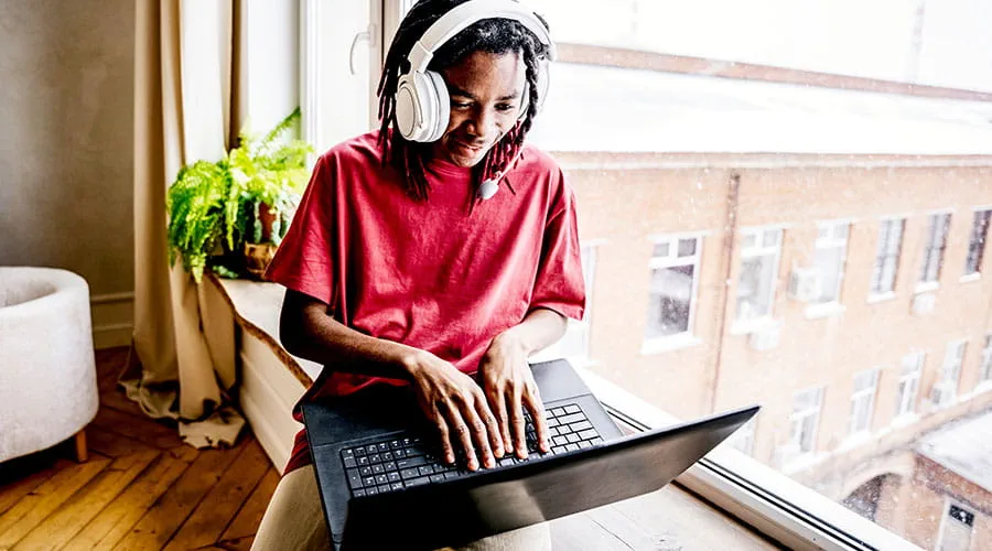 Person working remotely on laptop Person working remotely on laptop