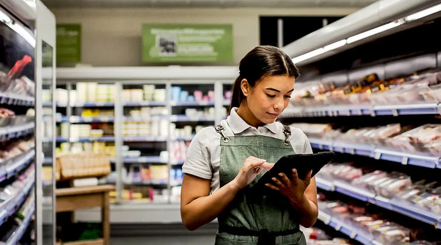 Worker stocking shelves in supermarket Worker stocking shelves in supermarket