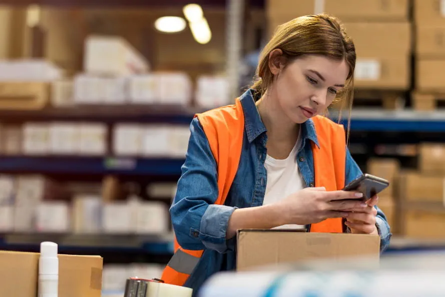 Mitarbeiterin im Logistiklager nutzt Adecco App Mitarbeiterin im Logistiklager nutzt Adecco App